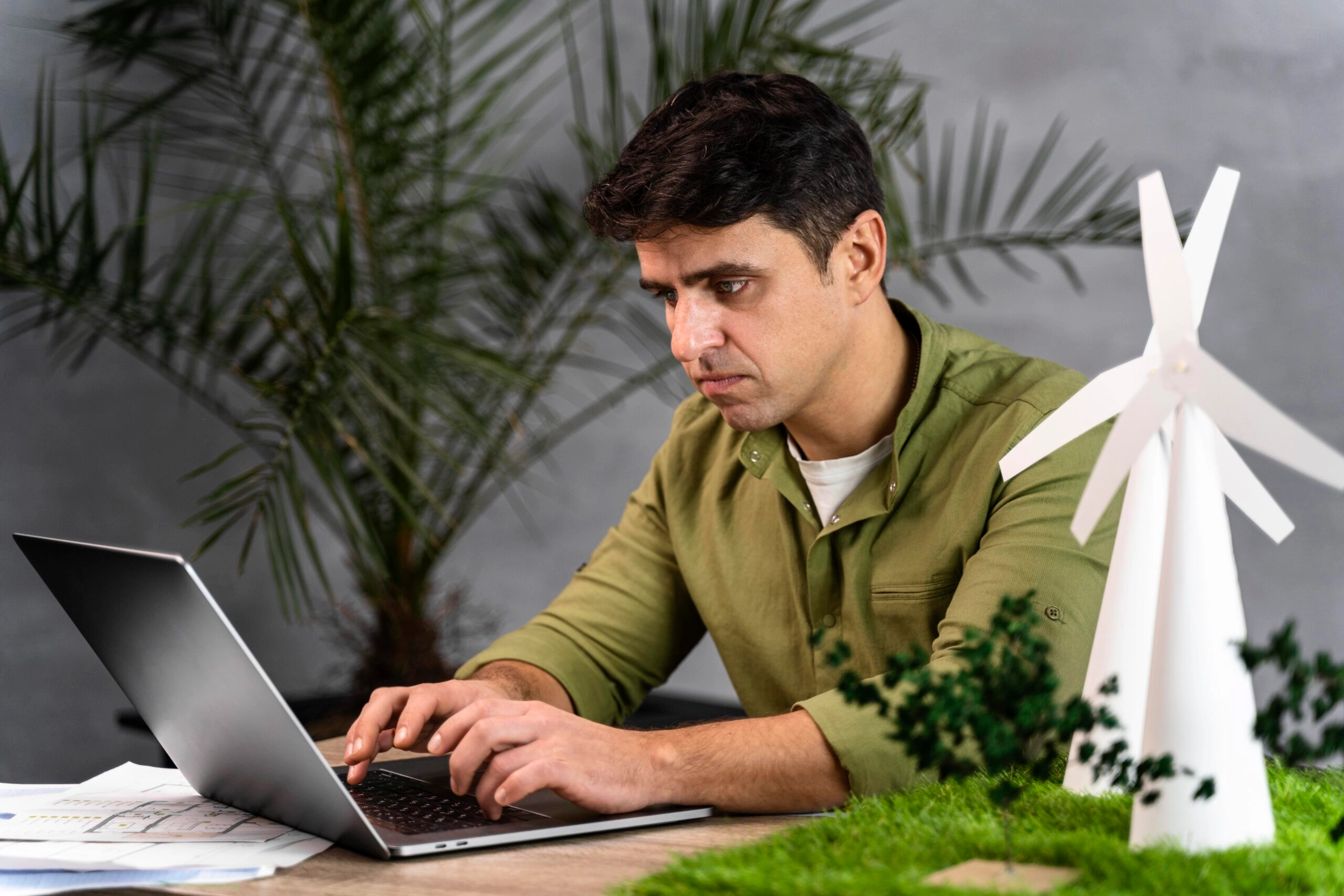 side view man working eco friendly wind power project with laptop scaled 1